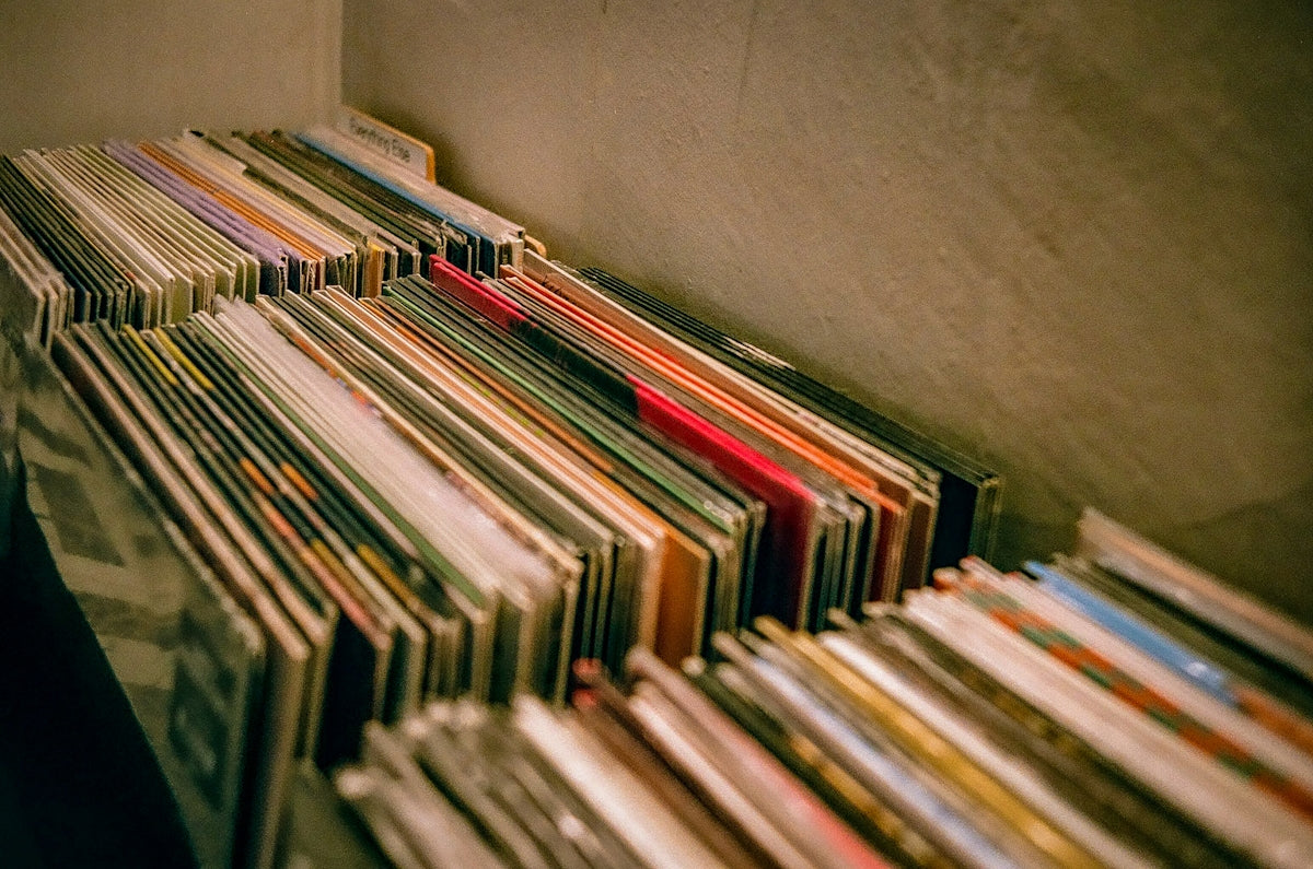 a bunch of records sitting on top of a shelf